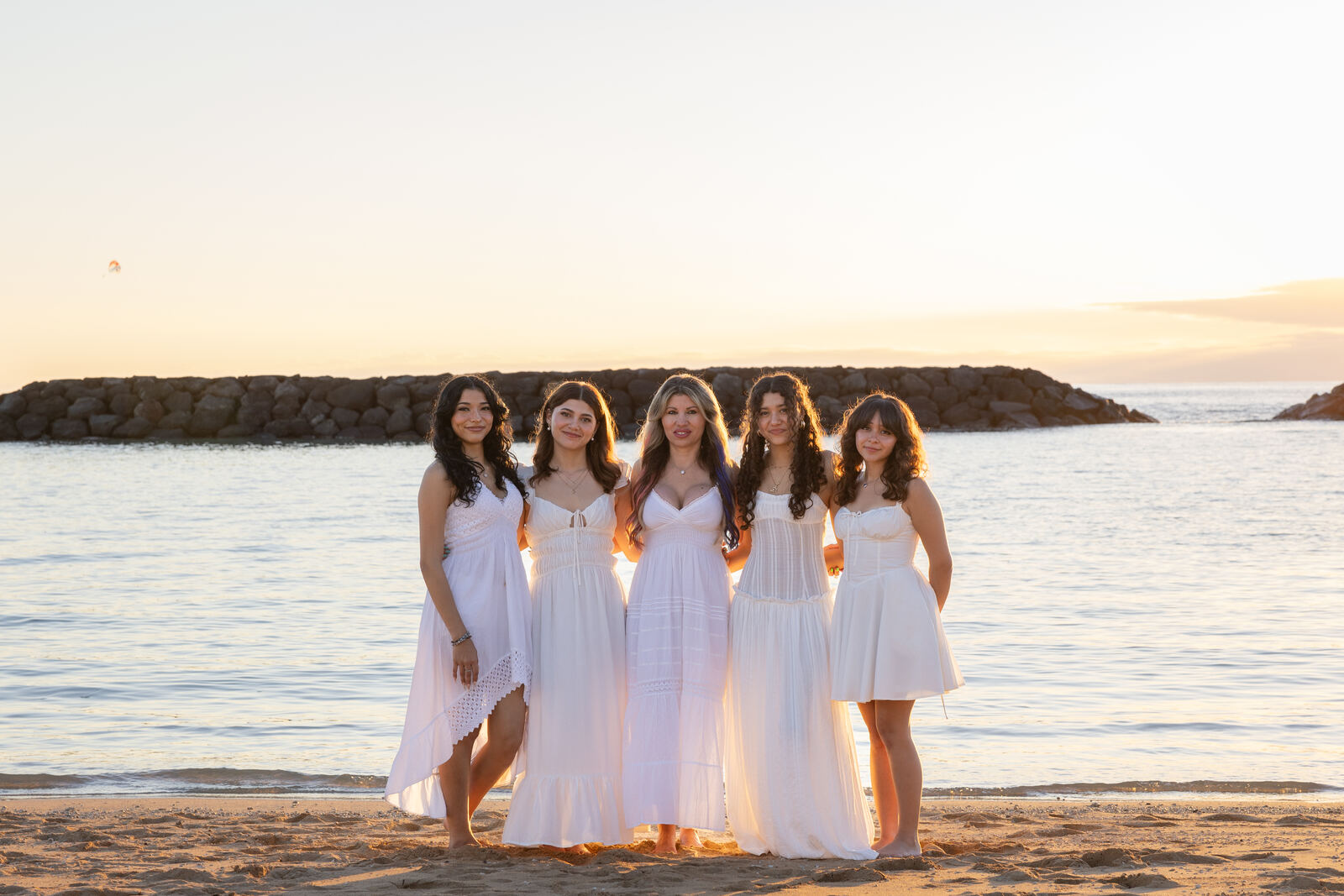 Mother and daughters on the beach at sunset