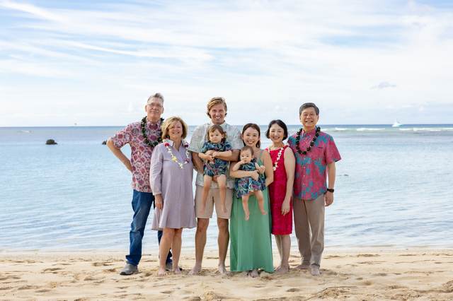 Multi-generational family group posing together on the beach