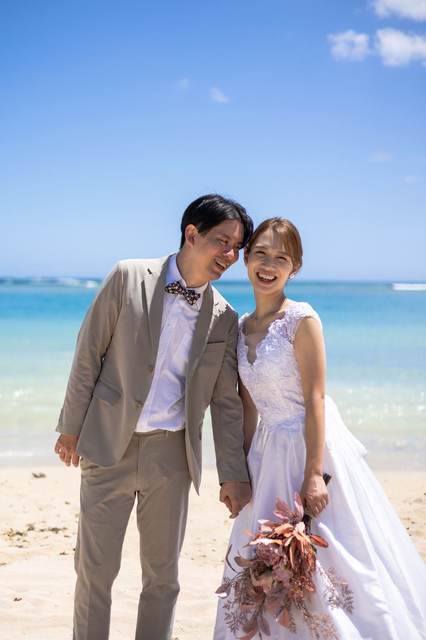 Couple laughing together on the beach in wedding attire